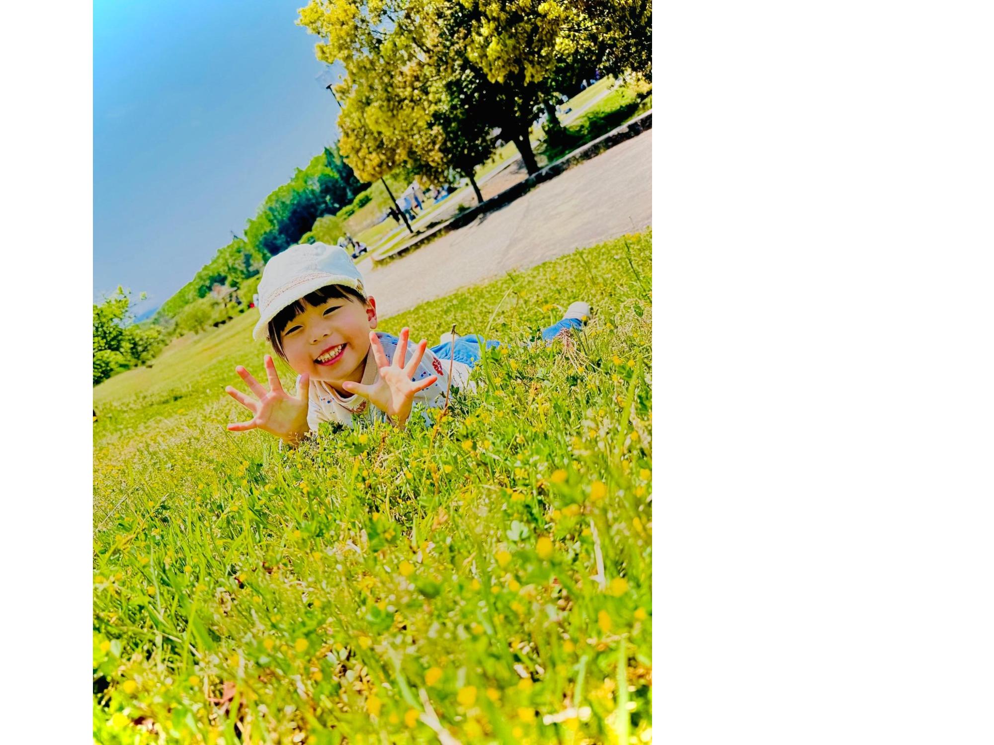 公園に寝そべるこどもの画像