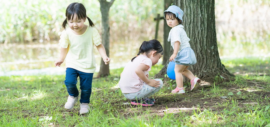 森で女の子3人が遊んでいる様子の写真