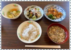 白米と汁物と2品のおかずとフルーツが並べられている写真