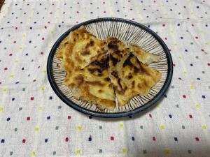 三角形に切り分けられている玉ねぎの入ったチヂミの写真