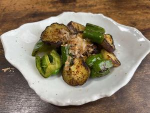 炒めたなすとピーマンに鰹節をかけた料理の写真