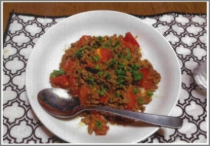 パセリが振りかけられたトマトとひき肉が入ったキーマカレーの写真