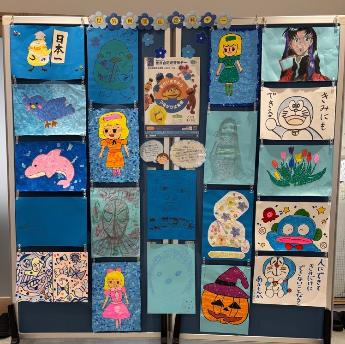 生涯学習センターに掲示されたブルーフラッグの写真。青い画用紙に絵や折り紙、シールなどで作られた作品。