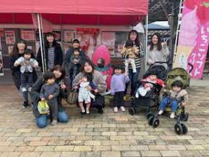 屋台の前で記念写真に臨む親子連れの写真