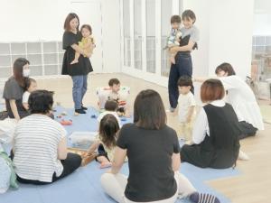 床に座りながら談笑しているひよこクラブの親子たちの写真