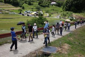 ガイドに連れられて多くの観光客が遊歩道を歩いている写真