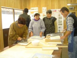 そば打ち体験を楽しむ人たちの写真