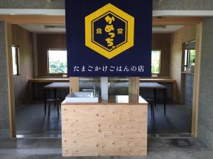 店名が書かれた暖簾がかかっている食堂かめっちの入り口の写真