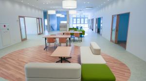 淡い光に照らされる机や多人数用の椅子の写真