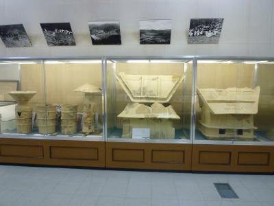 出土品の入れられたショーケースの上に白黒写真のパネルが飾られている写真