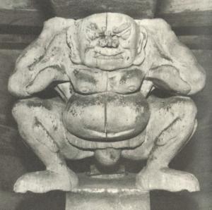 中腰で膝に肘を置いた人の石造の写真