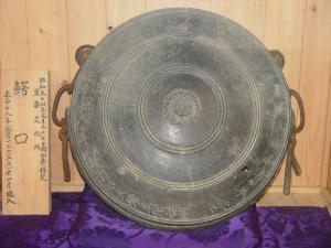 木のキャプションと鰐口が並べられている写真