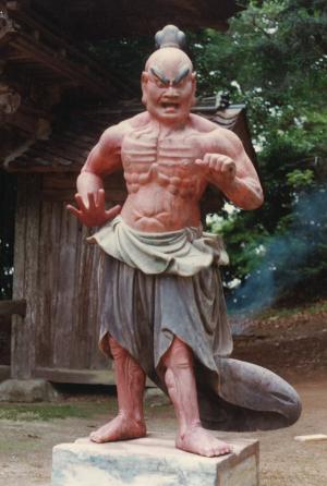 吊り上がった眉毛をした上半身裸の男性像の写真