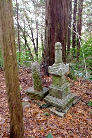 森の中に置かれた2種類の石塔の写真