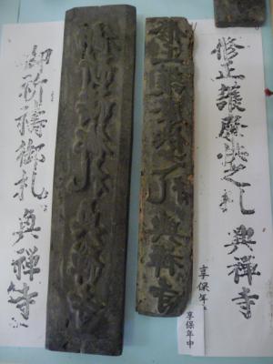 文字が彫られた2種類の版木と刷られた紙の写真