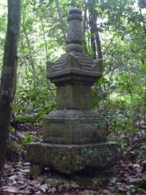 森の中に置かれた石塔の写真