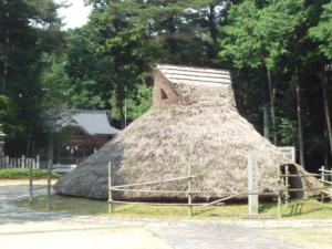 柵で囲われた竪穴式住居の写真