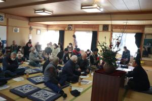 畳の部屋で前方に座っている方の話に耳を傾ける町民の方々の写真