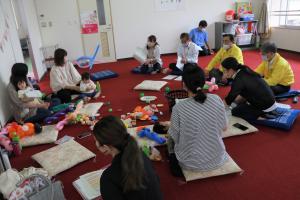 子どもと一緒に輪になって会話をかわすお母さんたちの写真