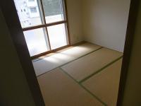 大きな窓から日差しが差し込んでいる4畳半の和室の写真