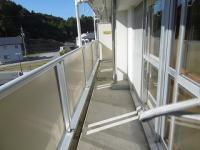 透明なパネルで隣室と仕切られているベランダの写真