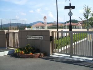 奥に校庭と校舎が見える美咲町立美咲中央小学校と書かれた門の写真