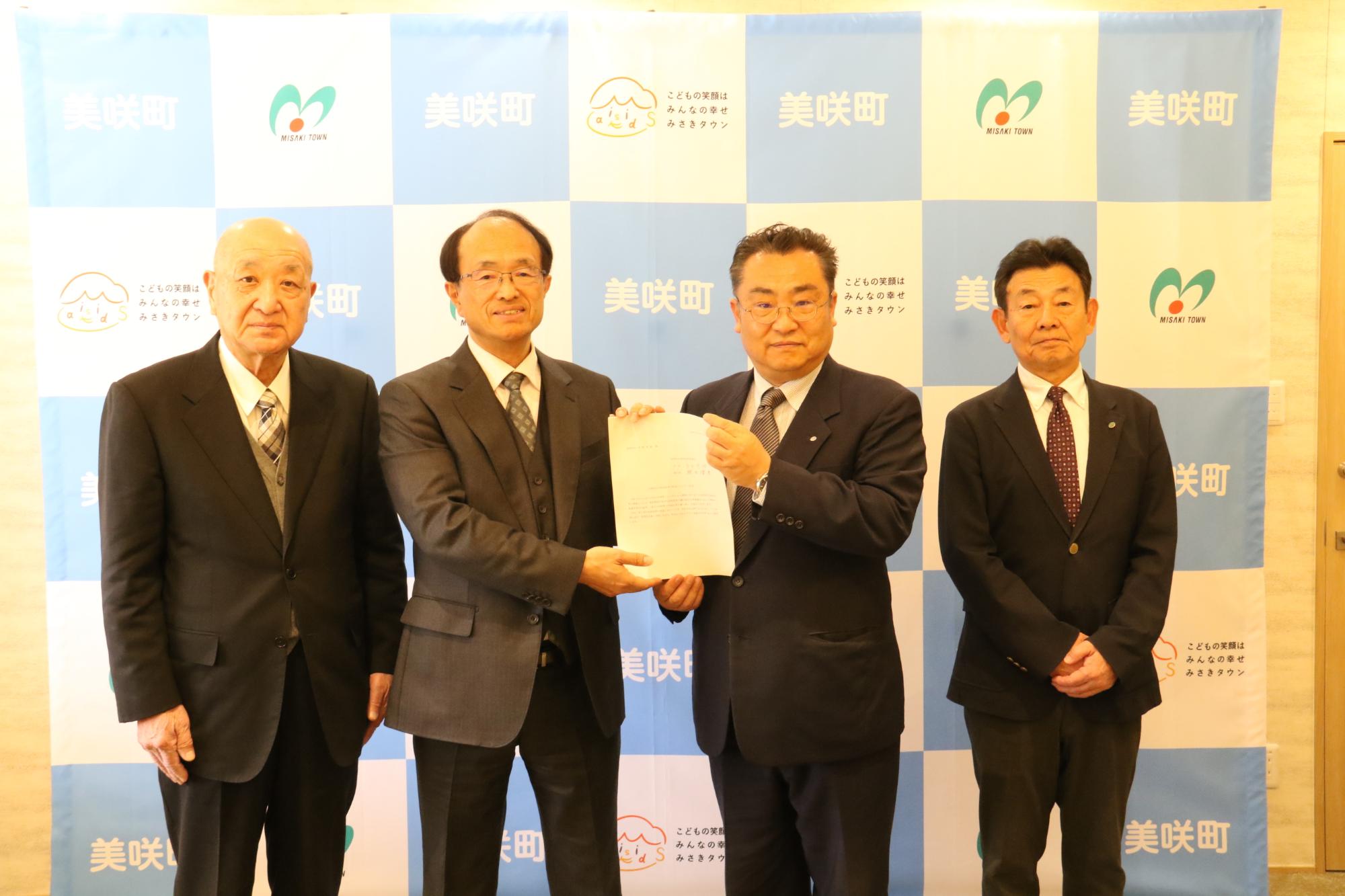 第3次美咲町行財政改革大綱の答申を行った審議会委員2人と、青野町長、忠政副町長が横一列に並んでいる