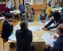 会議室で机の上に広げられたアンケート用紙をチェックして集計を行っている写真