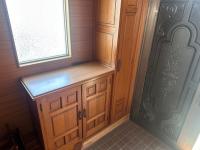 窓と腰高の靴箱に背の高い収納、その横に扉が配置された玄関の写真